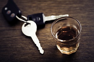 car keys next to glass of whiskey